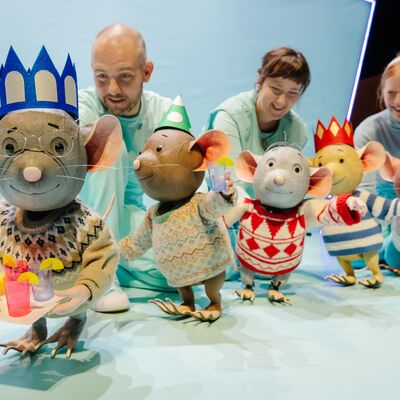 Four mice puppets in a line, wearing party hats.