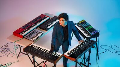 Zubin Kanga standing in the middle of keyboards in a square around him