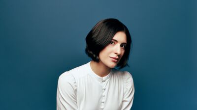 Mariam Batsashvili in a white blouse on a teal background