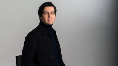 Vadym Kholodenko dressed in black casually sitting on a stool