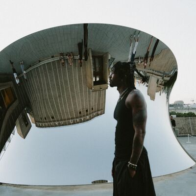 Person stood infront of mirrored sculpture