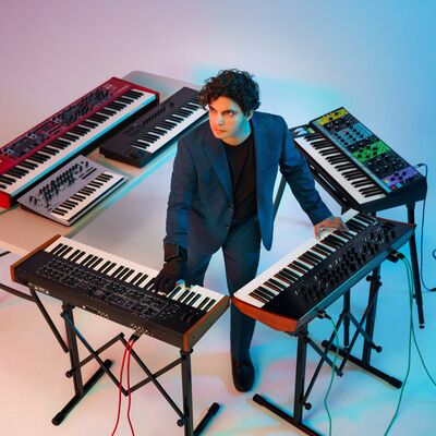 Zubin Kanga standing in the middle of keyboards in a square around him