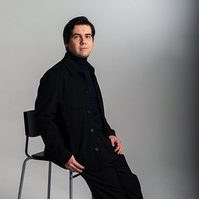 Vadym Kholodenko dressed in black casually sitting on a stool