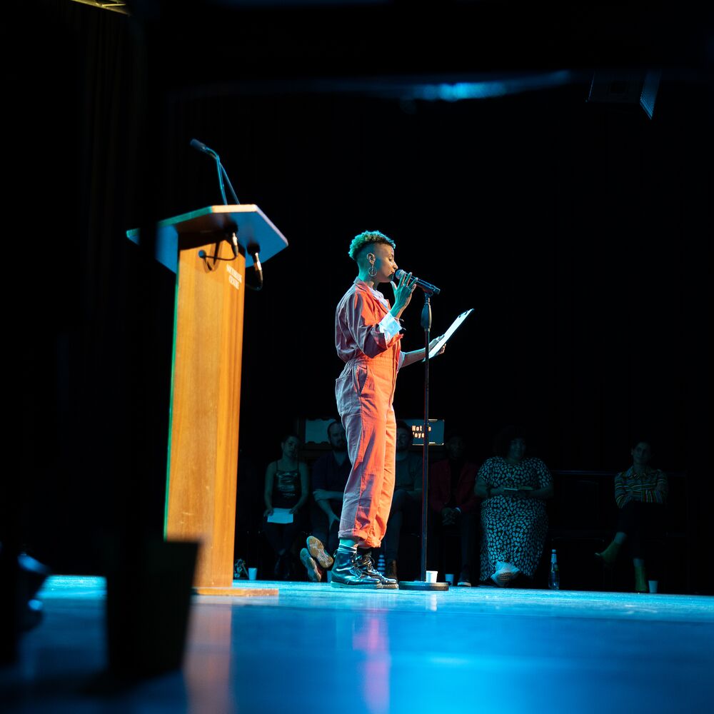 a picture of a performance on stage in front of a microphone