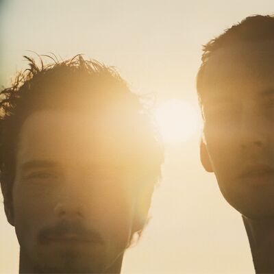 Close-up of two individuals in a sun-drenched scene, with soft lighting creating a warm and atmospheric effect