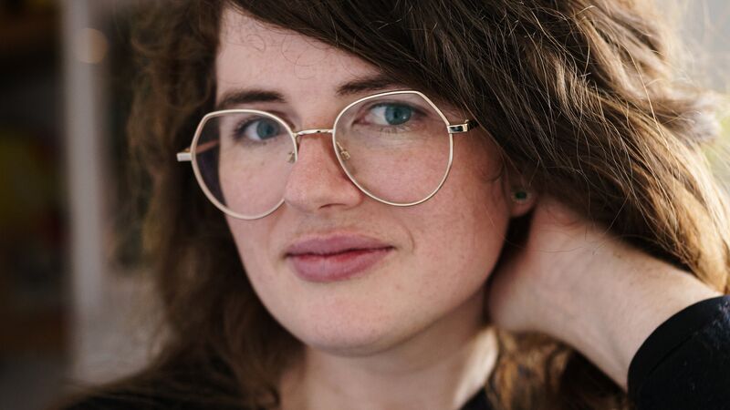 Painting of a figure with brown hair and tears coming out of one eye