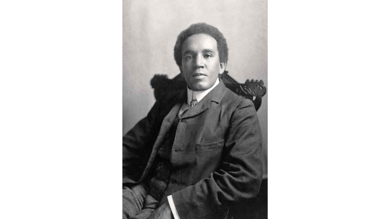 A person in a red tracksuit sits on a bench outside the Hayward Gallery