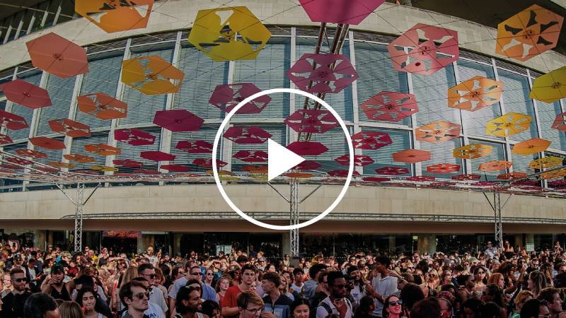 People dancing at a Southbank Centre event. A play button is overlaid on the image, meaning that clicking will open a video.