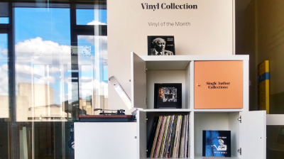 An image of the vinyl collection in the National Poetry Library, showing shelves of vinyl with a sign above that says "Vinyl Collection - vinyl of the month"