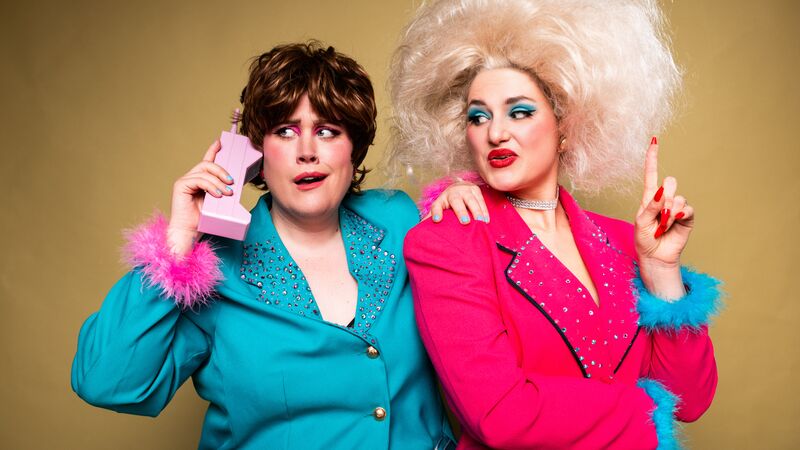 Two people dressed in business casual in power poses, one of them is taking a call on a comically large phone