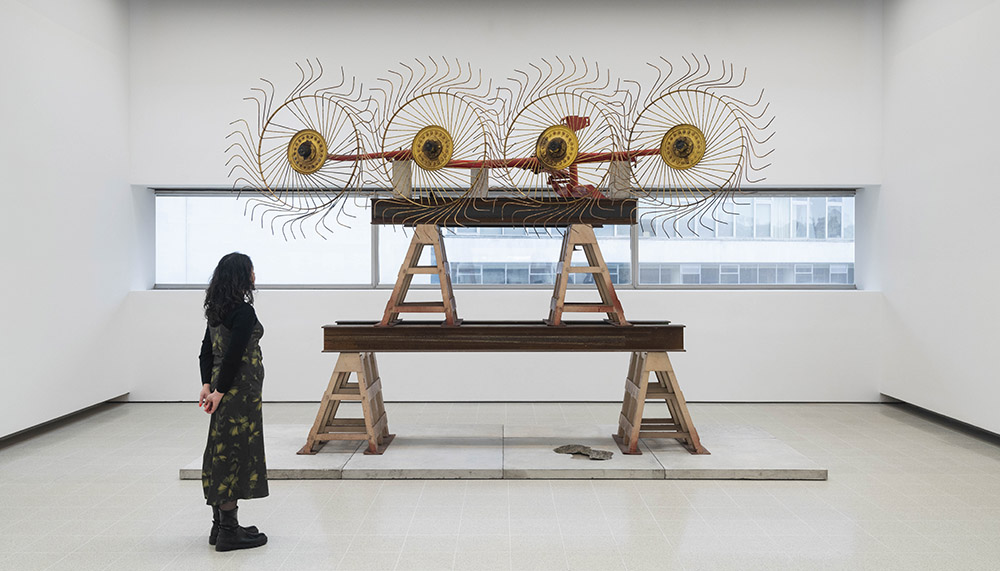 Installation image of woman looking at Mike Nelson artwork the Hayward Gallery
