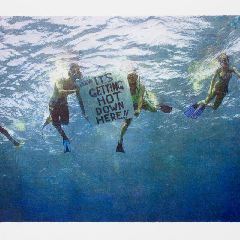 Scuba diving activists holding a poster sign under the sea 'IT"S GETTING HOT DOWN HERE!!'