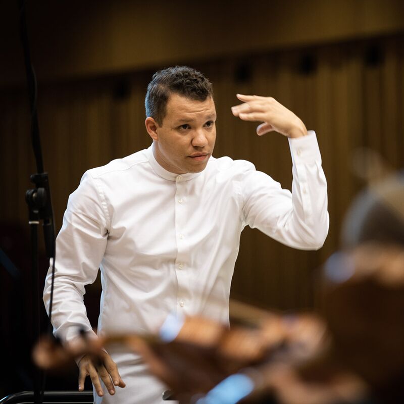 Candid portrait of Ryan Bancroft conducting an orchestra