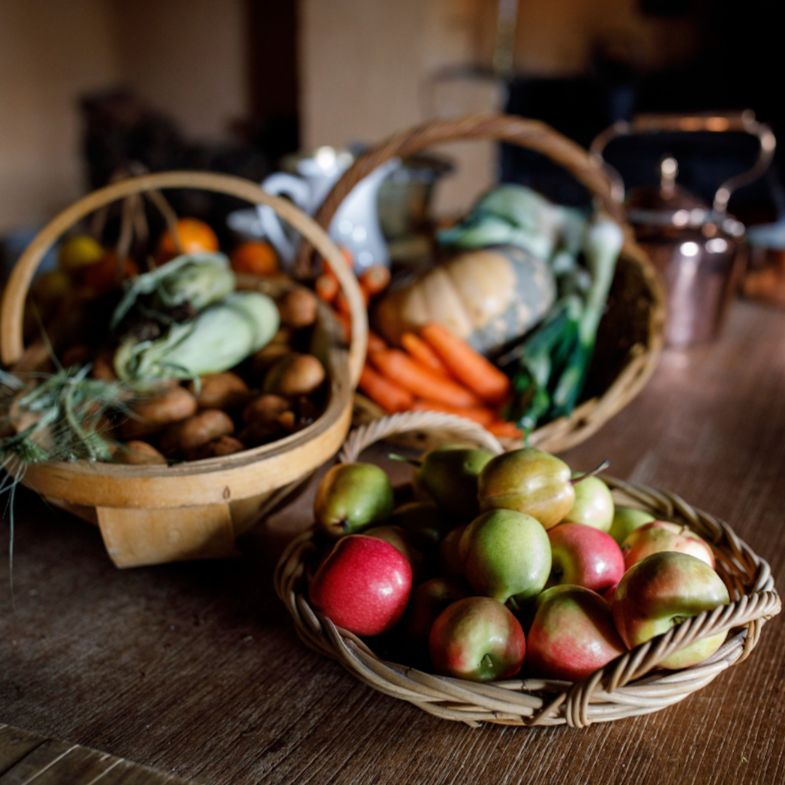 Baskets of fruit and vegetables on wooden table