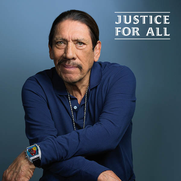 Danny Trejo in a blue collared shirt.