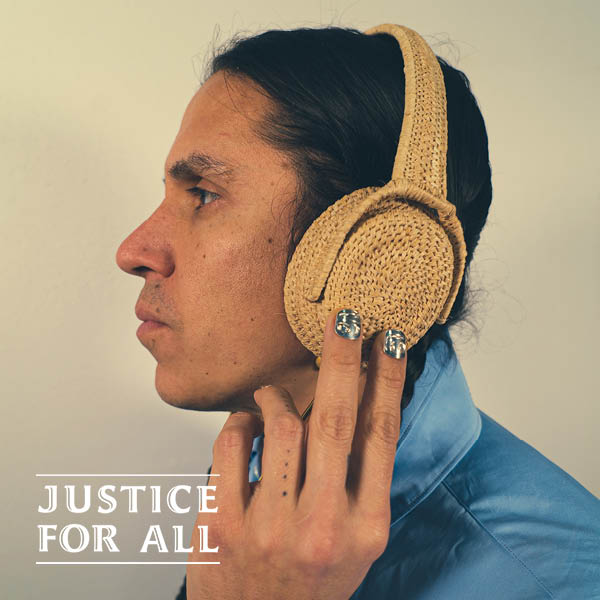 Nicholas Galanin wearing a blue collared shirt and woven headphones.