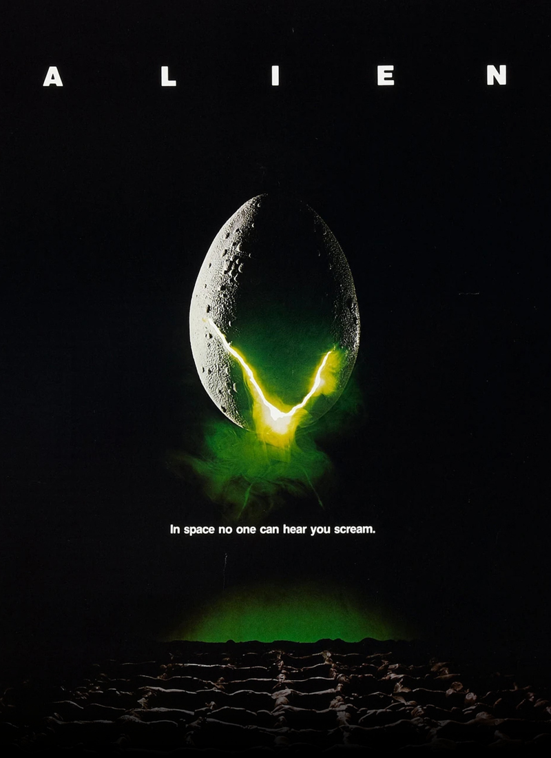 Alien movie poster with a green light shining through a crack in an egg shell.