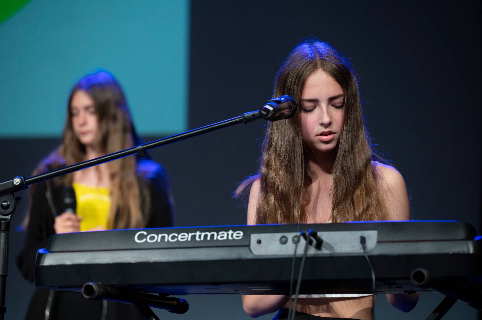 Two performers singing and playing the keyboard.