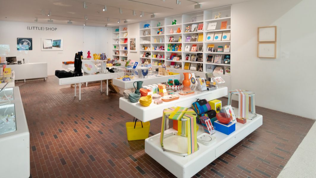 Photo of the Walker Shop. Brick floors and white tables display colorful items.